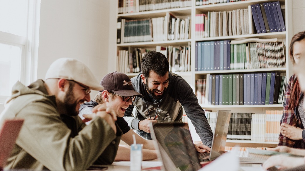 group of men laughing at laptop