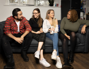 four people on a sofa talking