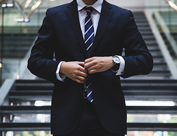 man buttoning up blazer