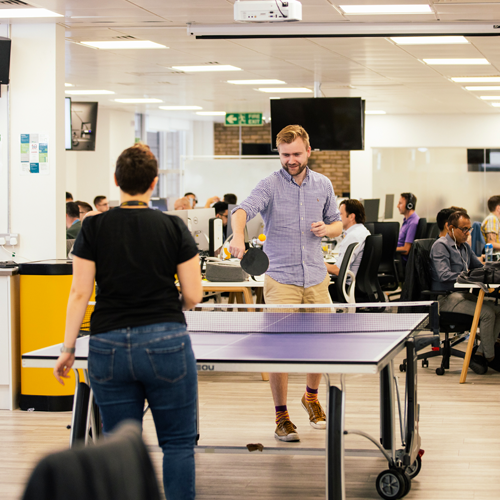 two employees playing ping pong