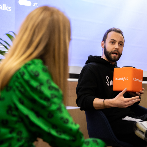 man holding talentful cube and talking