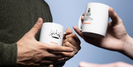 two people holding talentful mugs