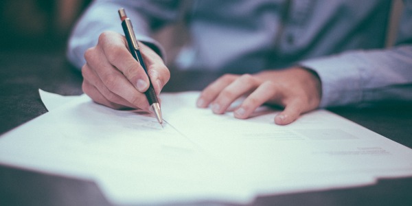 Simply Business image, man writing on a piece of paper