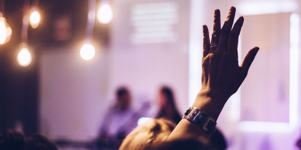 Hopin image, person's hand in the air at a conference